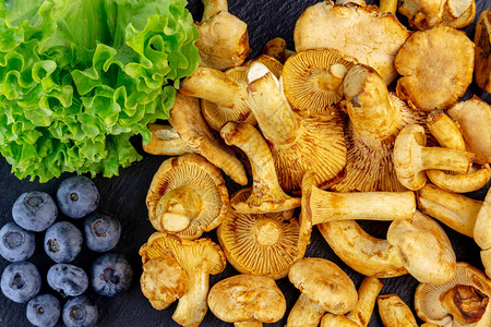 鸡油菌蘑菇配蓝莓和绿色沙拉的背景图片