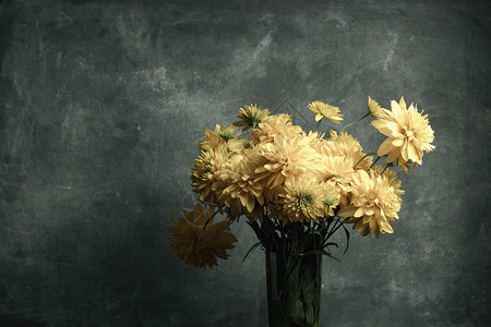 黑色玻璃桌上的花瓶里的黄色花朵美丽的图片