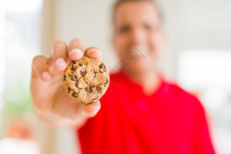 中年男子在家里吃巧克力薯饼图片