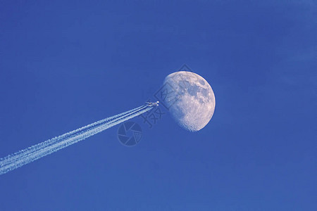 现代喷气式飞机月亮在蓝天空上作为背景制造太空梭飞图片
