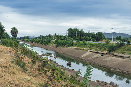 混凝土墙中的灌溉渠或灌溉渠道将水从库输送到泰国雨季干燥背景图片