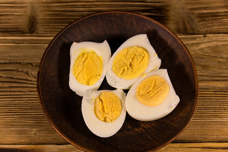 在木桌上的盘子上煮鸡蛋顶视图图片