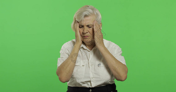 徽标ps素材一位年长的妇女因头痛而苦一件白衬衫的老俏丽的祖母放置您的徽标或文本色度键绿屏背景背景
