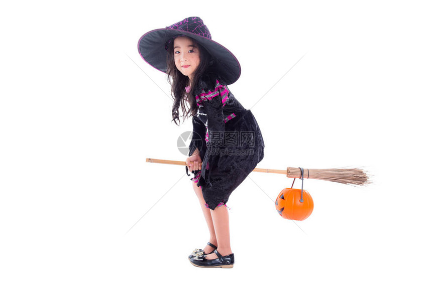 穿着圣礼服的亚洲小女孩骑着扫帚在白色背景图片