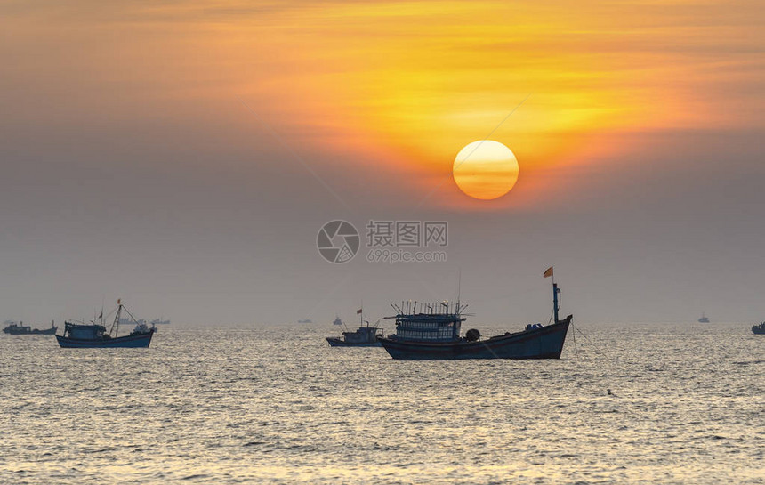 海景黎明时渔船出海捕捞鱼以迎接图片