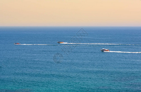 在蓝色海湾快速冲浪的快艇图片