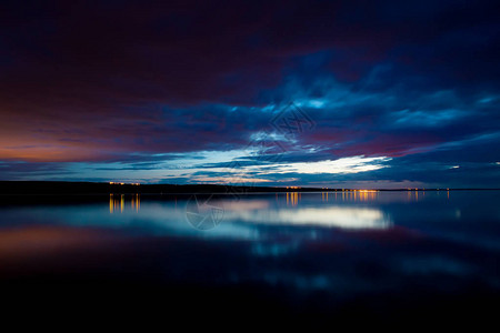 夜空和大海和平静的水与云彩的日落天空图片