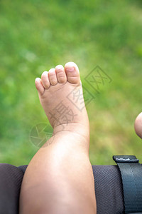 一个混血男婴在公园草地上的新鲜空气中悬挂着裸露的皮肤胖乎的图片