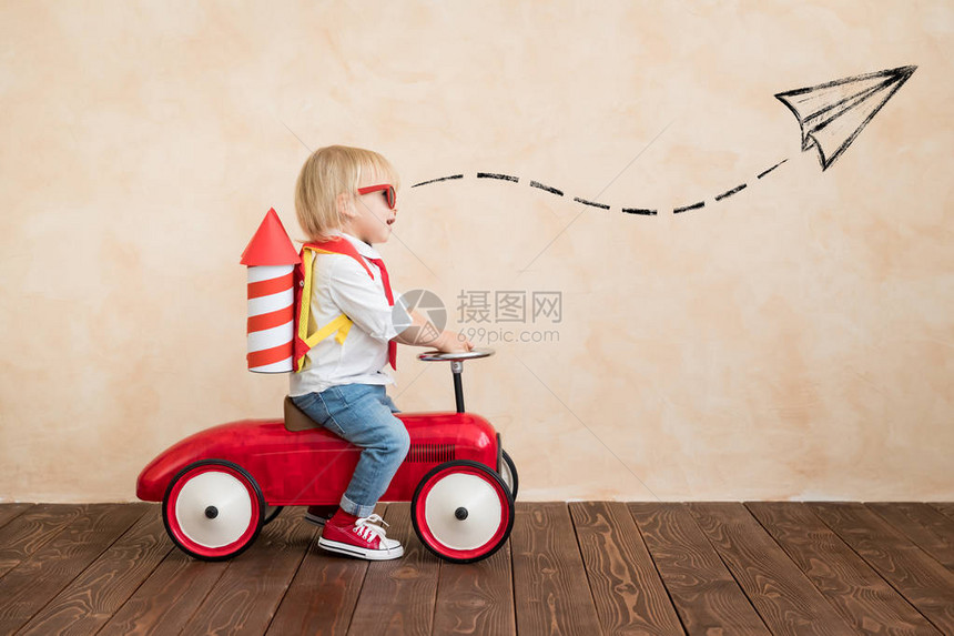 带着玩具喷气机包的有趣小孩在家里玩乐快的孩子成功想象力和图片