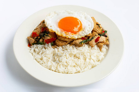 米饭配上炒鸡和圣罗勒煎鸡蛋白色背景图片