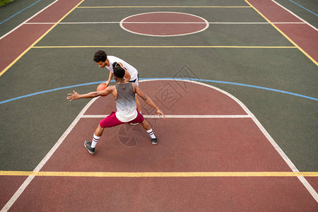 年轻运动员在球场上打篮球时图片