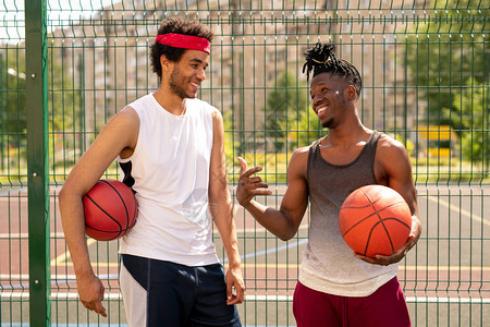 两个年轻的友好篮球玩伴讨论一些有趣的游戏时刻图片
