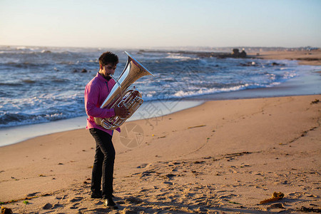 在海滩上演奏大号的音乐家图片