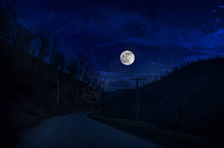 满月之夜穿过森林的山路夜间乡村道路风景明亮图片