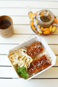 黑果茶藨白木桌上放着黑果茶烤鱼和米饭的水壶背景