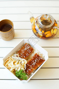黑果茶藨白木桌上放着黑果茶烤鱼和米饭的水壶背景