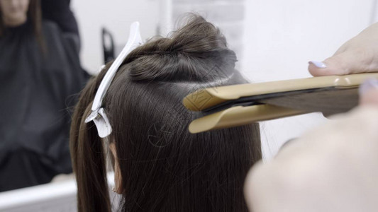 理发师在美容院里给一个头发染黑的姑娘做发粉背景图片