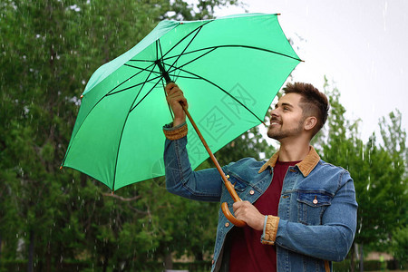 雨天在户外打伞的男人图片