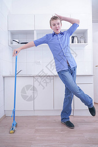 穿蓝牛仔裤的好少年男孩帮助他独自清扫公寓在白色房背景图片