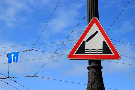 蓝色天空背景的柱形上的警告路标拖桥安装在摇图片