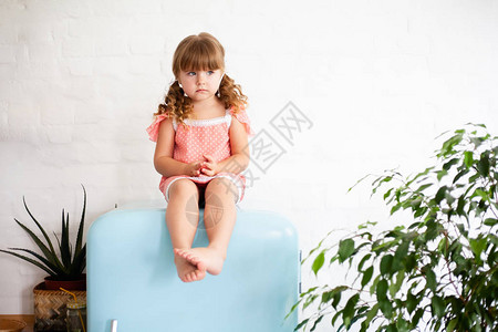 小女孩坐在冰箱上图片