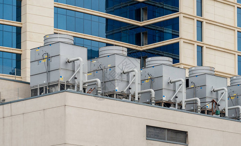 现代酒店商务中心摩天大楼屋顶六台大型交流空调暖通空调机背景图片