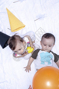 两个婴儿玩气球和生日帽子图片