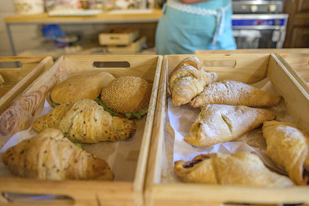 面包店柜台的羊角面包和汉堡在面包店的篮子图片