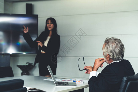 高级执行经理在会议室听取年轻女商人的财务介绍秘书向老板汇报商业图片