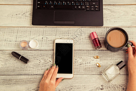 女手智能手机笔记本电脑咖啡杯香水和化妆品图片