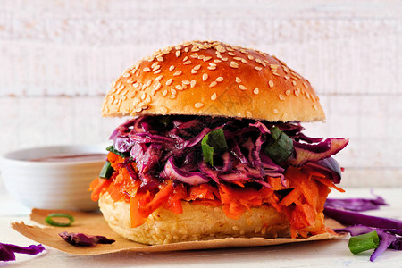 无肉胡萝卜汉堡加红卷心菜长着针对白木背景的草布健康饮食图片