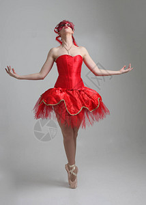 穿着红色芭蕾舞裙和面具的女孩的全长肖像在工作图片