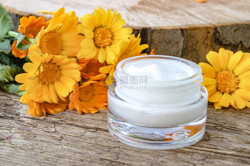 一罐白化妆品奶油用于身体护理木上鲜橙色圆筒花图片