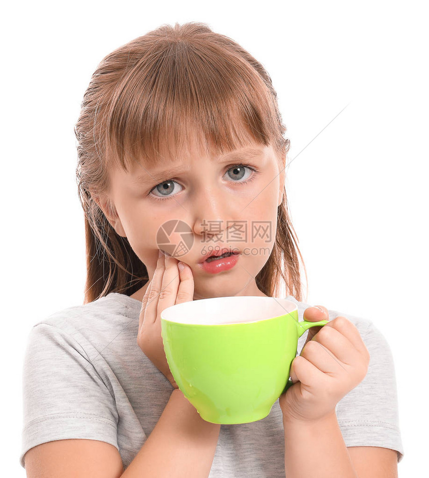 带着敏感的牙齿和茶杯的小女孩在白色背图片