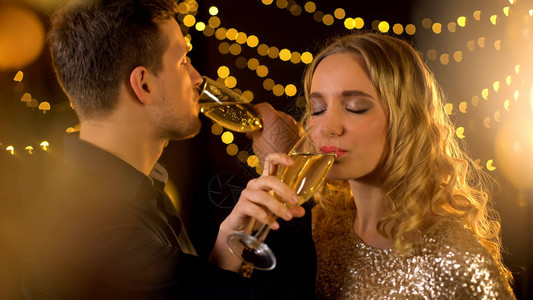 快乐的年轻夫妇喝香槟兄弟情谊情侣在派图片