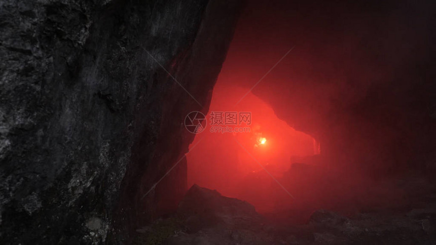 黑暗洞穴中的旅行者影视素材拿着红色火炬的人穿过黑暗洞穴的狭窄隧道对岩洞中的通道进行危险图片