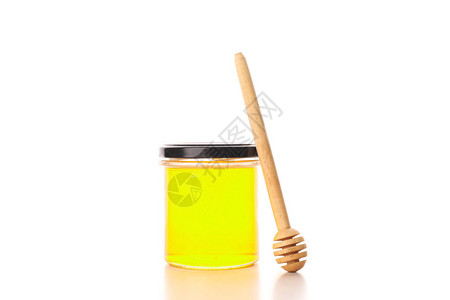 带蜂蜜的玻璃罐和白底图片