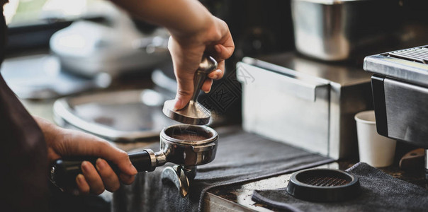 女咖啡师手在咖啡馆用研磨机碾图片