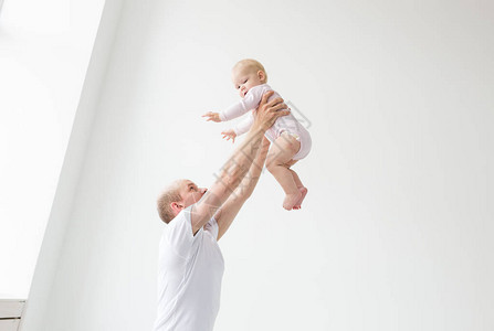 父亲举起女婴快乐的父亲捡起并扔掉他举起一个小孩家庭气氛图片