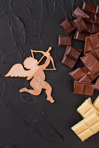 丘比特和巧克力块的木图浪漫背景与胶合板恋情和各种巧图片