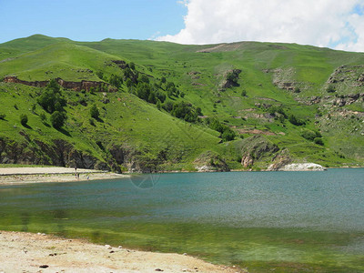 清澈的湖水倒映着被绿草覆盖的山脉图片