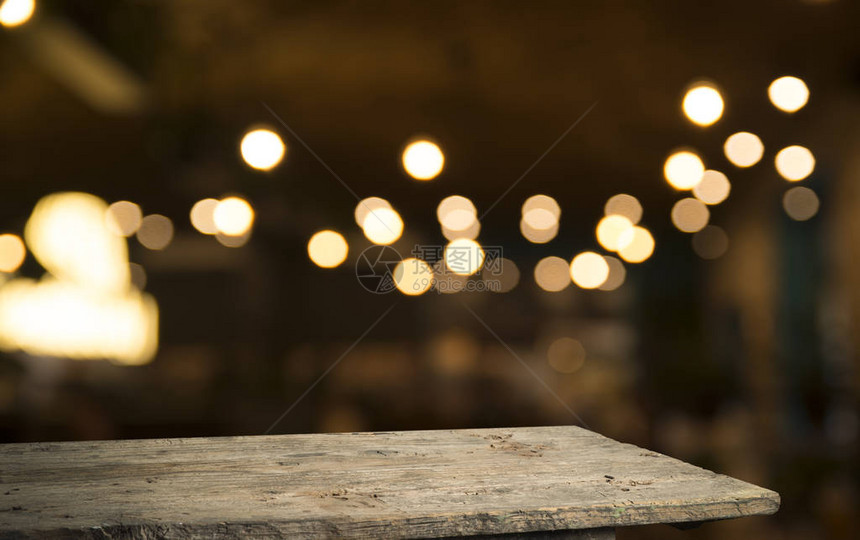 深色背景下咖啡馆餐厅模糊浅金色散景上的空木桌面图片
