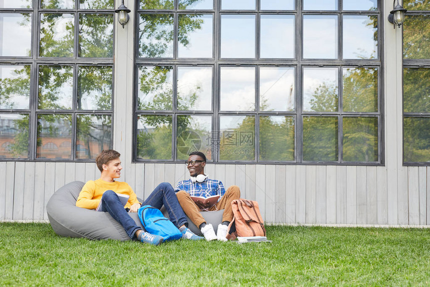 两名学生在大学校园室外休息的全长肖图片