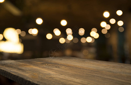 深色背景下咖啡馆餐厅模糊浅金色散景上的空木桌面背景图片