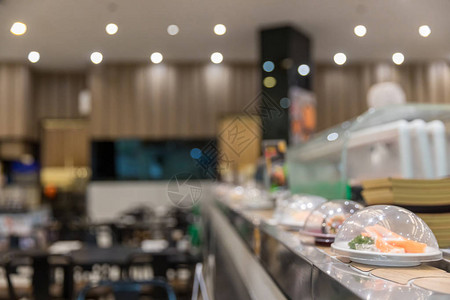 日本餐厅寿司传送带或式自助餐带寿司在背景模图片