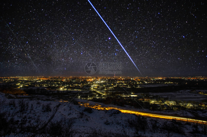 夜晚的城市在星空和银河背景的天际图片