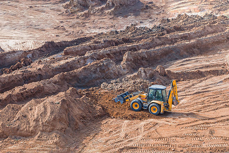 轮式装载机挖掘机在施工现场工作土方工程期间沙坑背景图片