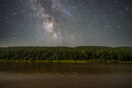 夜晚的河流以星空和银河为背景图片