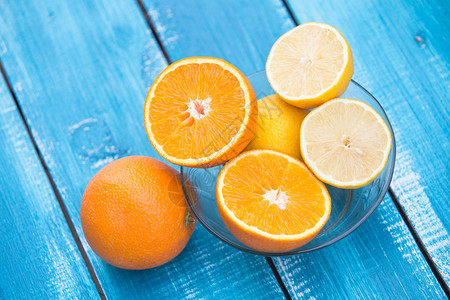 蓝色木质背景中的柑橘类水果图片