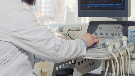 使用超声波扫描仪对一名男医生进行裁剪后视图无法辨认的男产科医生检查患者超声扫描的结果医背景图片